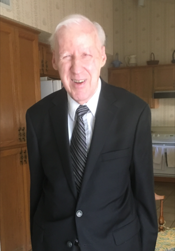 Rollie wearing a suit and posing in his kitchen