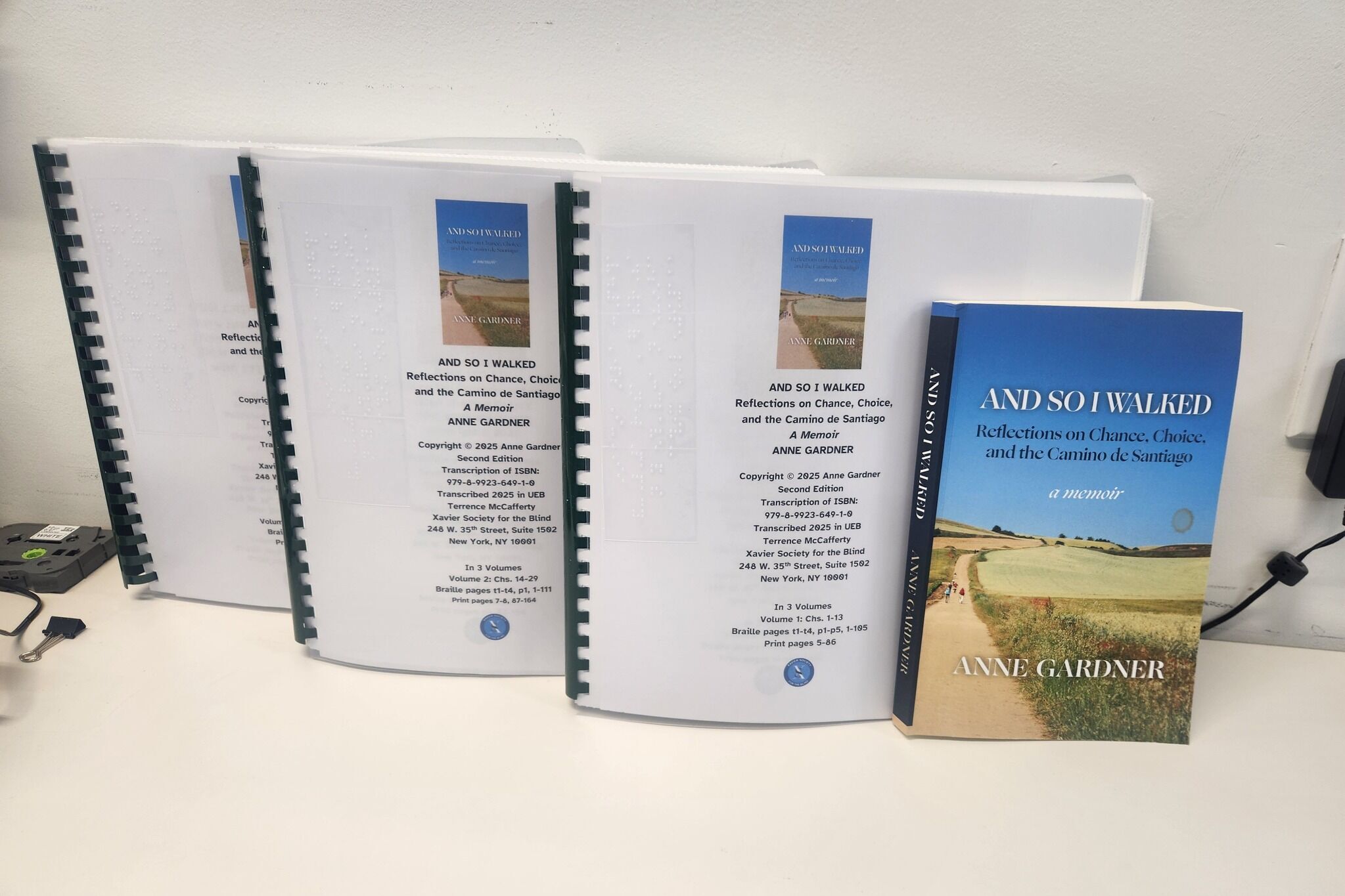 Three volumes of braille with print version of the book
