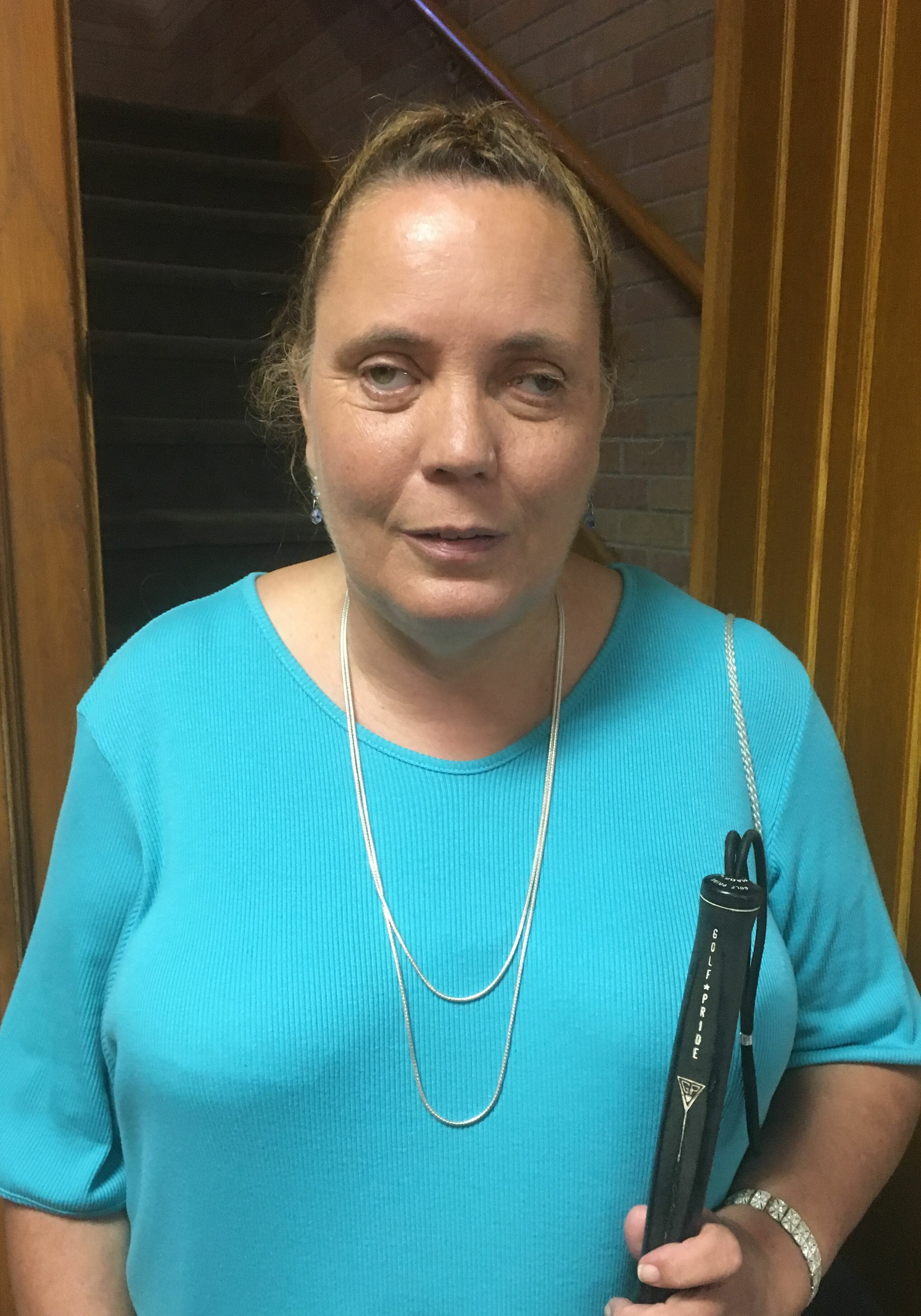 Dee wearing a beautiful blue shirt with her cane pictured in her church