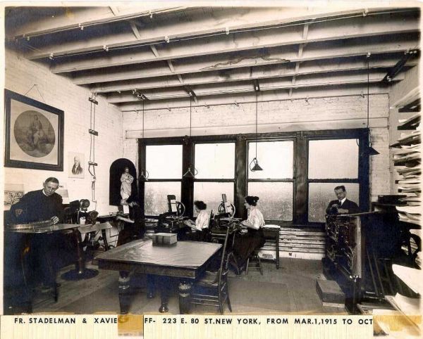 An historic photo showing Father Stadelman at work with some staff at our previous location