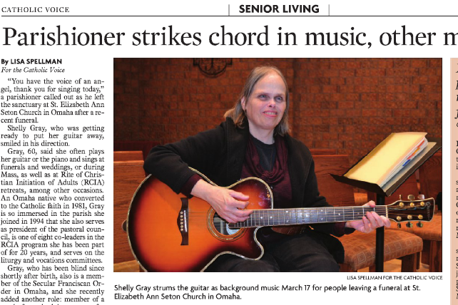 Screenshot of Omaha Catholic Voice showing Shelly Gray seated in her church with a guitar