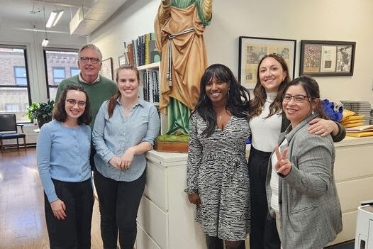 The ladies from Catholic Charities New York pictured with XSB staff and St. Lucy