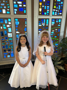 A young blind child with her sister after making their First Holy Communion
