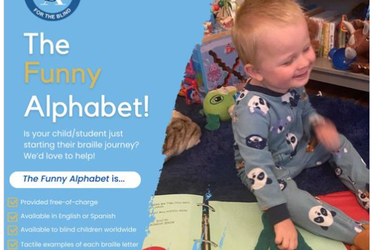 A young blonde baby pictured smiling while reading braille